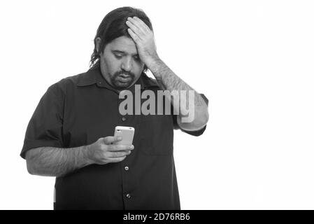 Fat uomo caucasico cercando stanco mentre si utilizza il telefono cellulare Foto Stock