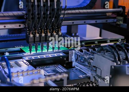 Assemblaggio della scheda a circuito stampato del computer - macchina di prelievo e posizionamento SMD automatica durante il lavoro in fabbrica. Tecnologia automatizzata, industriale, robotica Foto Stock