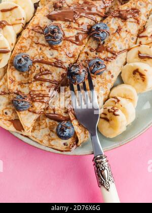 Crepes con cioccolato spalmato noci, banana, bacche Foto Stock