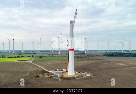 Sieversdorf, Germania. 20 Ott 2020. Una nuova turbina eolica è eretta su un campo (fotografia aerea scattata con un drone). Sullo sfondo sono le turbine eoliche dell'azienda eolica "Odervorland" nel distretto di Oder-Spree. Credit: Patrick Pleul/dpa-Zentralbild/ZB/dpa/Alamy Live News Foto Stock