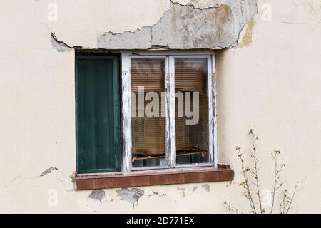 Una finestra su una vecchia casa danneggiata Foto Stock