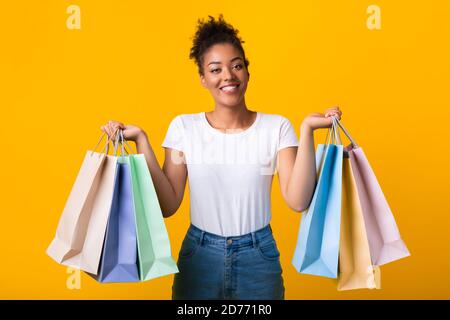 Ritratto di allegra donna nera che tiene borse per lo shopping Foto Stock
