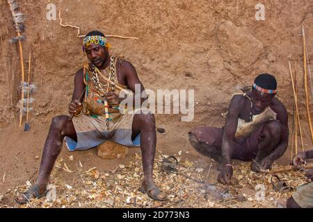 Uomini di Hadza che preparano le frecce prima di una spedizione di caccia. Gli Hadza, o Hadzabe, sono un piccolo gruppo etnico nella tanzania centro-settentrionale, che vive intorno a L. Foto Stock