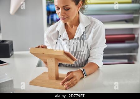 Graziosa assistente di negozio femminile che fa clic sullo schermo del tablet Foto Stock