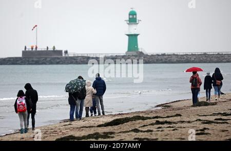 21 ottobre 2020, Meclemburgo-Pomerania occidentale, Warnemünde: Sul Mar Baltico gli escursionisti sono fuori sotto la pioggia. Foto: Bernd Wüstneck/dpa-Zentralbild/dpa Foto Stock