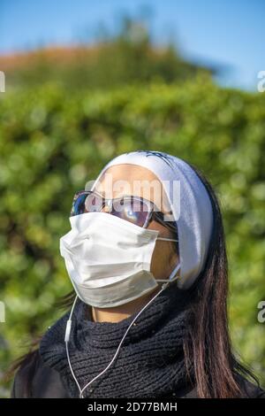 Donna che indossa maschera di salute in tempo all'aperto. Foto Stock