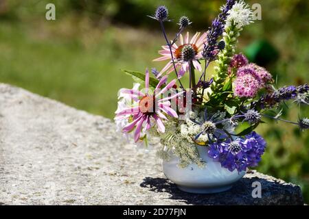 Un bouquet di fiori estivi in vaso bianco in una giornata estiva. Foto Stock