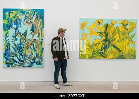 Londra, Regno Unito. 21 ottobre 2020. Un membro dello staff della galleria si pone accanto a 'Lightning', 2020, e 'Waidmannsheil', 2020, entrambi di Erika Navas. Anteprima di startnet Art Fair alla Saatchi Gallery di Chelsea. La fiera d'arte contemporanea espone la Londra locale, oltre che internazionali, gallerie e singoli artisti da tutto il mondo. La fiera si svolge dal 21 al 25 ottobre con i protocolli Covid-19 in atto per i visitatori. Credit: Stephen Chung / Alamy Live News Foto Stock