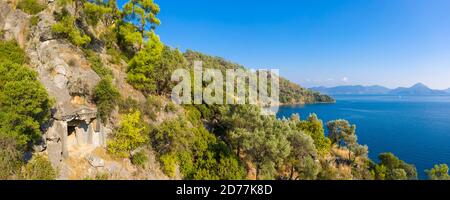 Vista panoramica sulla costa di un'antica tomba di roccia licana vicino alla località di Bedri Rahmi Koyu, Göcek, provincia di Muğla, Turchia Foto Stock