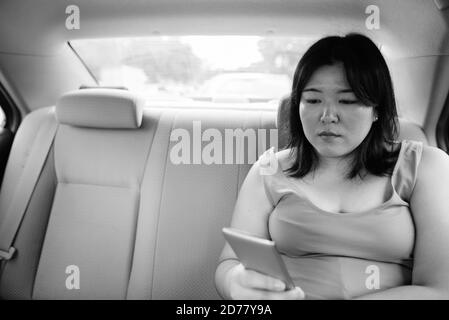 Bella donna asiatica in sovrappeso all'interno della macchina intorno alla città Foto Stock