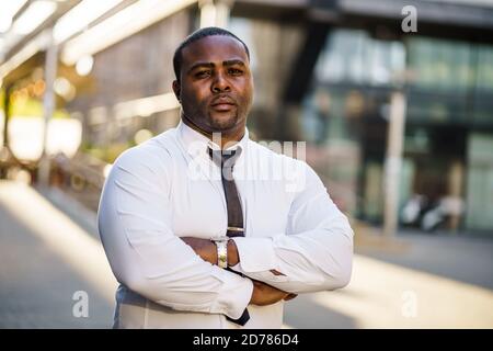 Ritratto di un serio imprenditore afro-americano di fronte alla costruzione dell'azienda. Foto Stock