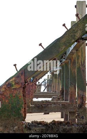 Una vista attraverso le vecchie difese marine derelict sulla costa nord del Norfolk a Happisburgh, Norfolk, Inghilterra, Regno Unito. Foto Stock