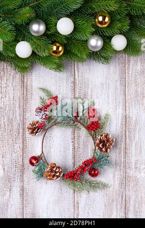 Corona di Natale , rami di albero con palla colorata su un tavolo di legno Foto Stock