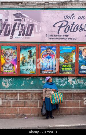 24 febbraio 2020: Donna in strada davanti ai poster dei film. POTOS», Bolivia Foto Stock