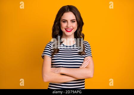 Foto di affascinante donna d'affari in striped tenuta di abbigliamento alla moda le mani si sono piegate isolatamente su uno sfondo giallo di colore brillante Foto Stock