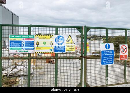 Avvertenze sulla sicurezza dei cantieri edili su un cancello d'ingresso a un cantiere, Kinsale, County Cork, Irlanda Foto Stock