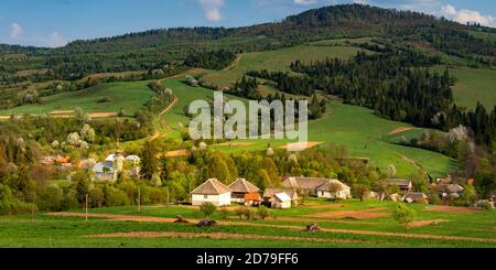 Paesaggio rurale con Volovets pittoresco villaggio al tramonto con verde Campi e colline nei Monti Carpazi Foto Stock