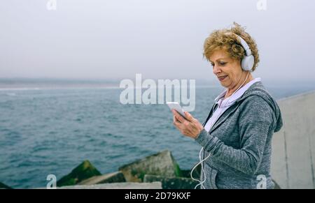 Senior sportive guardando il suo smartphone Foto Stock