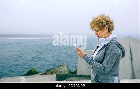 Senior sportive guardando il suo smartphone Foto Stock