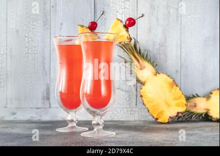 Due bicchieri di Singapore Sling su sfondo di legno Foto Stock