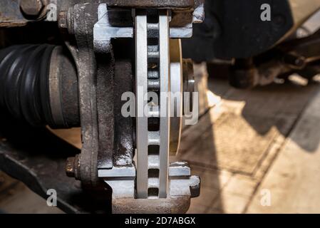 Nuovo disco del freno con rivestimento anticorrosione montato sul mozzo anteriore, un primo piano del sistema di ventilazione interna del disco del freno. Foto Stock
