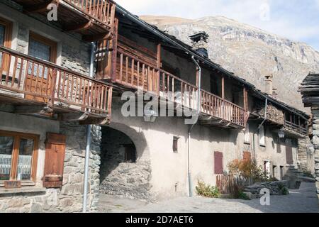 Vecchie case tradizionali in pietra con balconi e moutain sullo sfondo A Bonneval-sur-Arc Haute-Maurienne Savoie Rhône-Alpes Francia Foto Stock