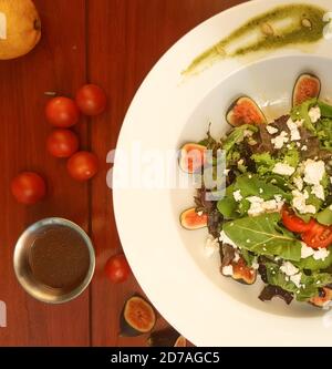 Un'insalata ad angolo con fichi, pomodori ciliegini e salsa Foto Stock