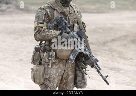 Soldato con mitragliatrice e bandiera del Mozambico su uniforme militare. Collage. Foto Stock