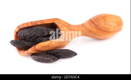 Fagioli tonka in paletta di legno, isolati su sfondo bianco. Fagiolo di Dipteryx odorata, cumaru o kumaru. Fagioli tonka dall'aroma fresco. Foto Stock