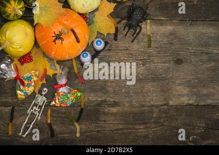 Sfondo cartolina di Halloween, zucche e dolci su un vecchio sfondo di legno con spazio di copia. Foto Stock