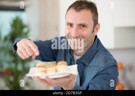 uomo che prepara tapas per i visitatori a casa Foto Stock