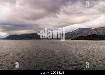 Canale di Sarmiento, Cile - 11 dicembre 2008: Ghiacciaio di Amalia e fiordo. Spessa nuvolosità bruna sopra e che copre la cima di montagne rocciose marroni a entrr Foto Stock