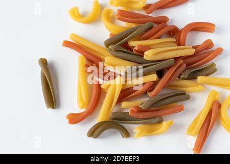 Pasta tricolore, macaron italiano in tre colori chiamato Caserecce su fondo neutro Foto Stock