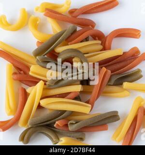Pasta tricolore, macaron italiano in tre colori chiamato Caserecce su fondo neutro Foto Stock