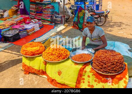 Stall che vende prodotti locali di cibo di strada, tra cui jalebi freschi e spuntini dolci in un mercato stradale in un villaggio a Madhya Pradesh, India Foto Stock