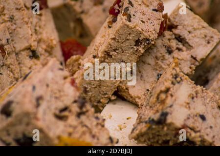 Macro shot di tofu sani pezzi di colore marrone con spezie rosse Foto Stock