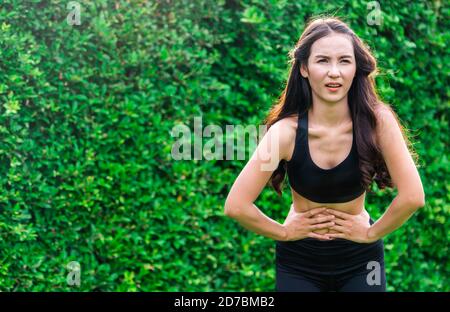 Sport giovane donna con il dolore al ventre. Il problema della salute concetto. Foto Stock