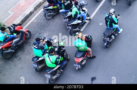 Giacarta, Indonesia - 7 febbraio 2020: Alcuni ojek, moto taxi, passeggeri in attesa di fronte alla stazione ferroviaria di Juanda su Jalan Ir. H. Juanda. Foto Stock