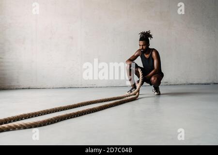 Immagine di atletico sportivo afroamericano che lavora con la battaglia corde interne Foto Stock