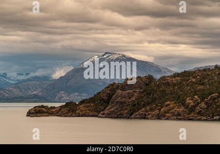 Canale di Sarmiento, Cile - 11 dicembre 2008: Ghiacciaio di Amalia e fiordo. Il paesaggio nuvoloso marrone e grigio copre parte della montagna innevata. Acqua del canale d'argento Foto Stock