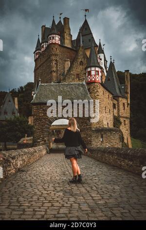 Foto verticale di una ragazza bionda vicino al castello Eltz a Wierschem, Germania Foto Stock