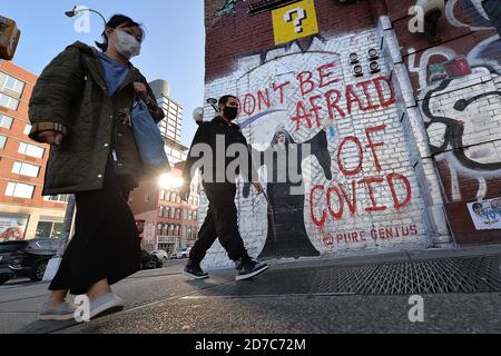 New York City, Stati Uniti. 21 Ott 2020. La gente passa davanti a un murale su Houston Street che raffigura il presidente degli Stati Uniti Donald Trump come il triste reaper come i casi COVID-19 continuano ad aumentare negli Stati Uniti, New York, NY, 21 ottobre 2020. Il murale è stato dipinto da un artista che prende il nome di "Genius reale", le parole "non avere paura di Covid" sono state pronunciate dal presidente Trump durante la ripresa dal COVID-19. (Anthony Behar/Sipa USA) Credit: Sipa USA/Alamy Live News Foto Stock