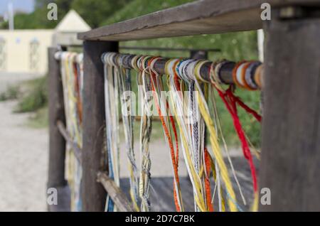 Vista delle filettature colorate appese in un corrimano di legno vicino la spiaggia Foto Stock