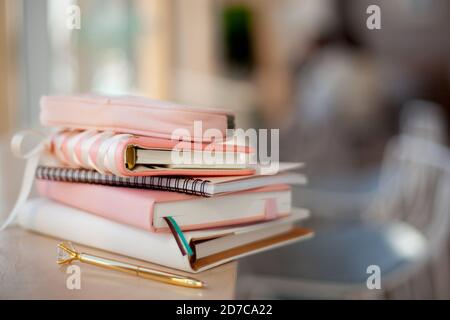 elegante corallo e una pila di diari di colore bianco con penna d'oro. Foto Stock