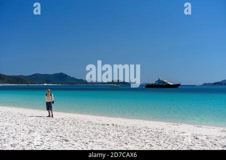 WHITSUNDAYS, AUSTRALIA - 24 AGOSTO: Turista maschile con zaino godendo il paesaggio e la sabbia bianca di silicio di Whitehaven Beach nel Whitsunday Pas Foto Stock