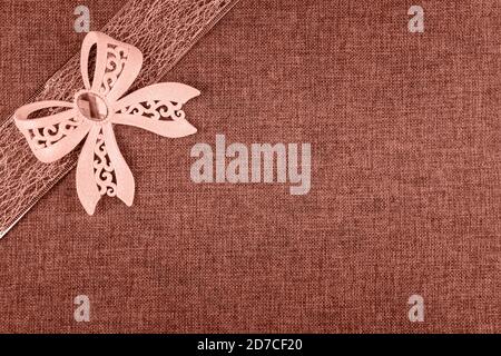 Elegante corallo brillato fiocco legato su nastro corallo colorato e su corallo naturale burlap. Sfondo orizzontale del biglietto d'auguri con ampio spazio per la copia e deco Foto Stock