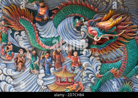 Un fregio al Tempio di Yueh Hai Ching, Philip St., Singapore, che raffigura un drago marino e vari personaggi sul mare o che attraversano il mare Foto Stock