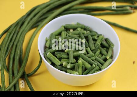 Pezzi di fagioli lunghi o pungenti in ciotola bianca, ingrediente di cottura Foto Stock