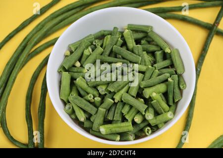 Pezzi di fagioli lunghi o pungenti in ciotola bianca, ingrediente di cottura Foto Stock