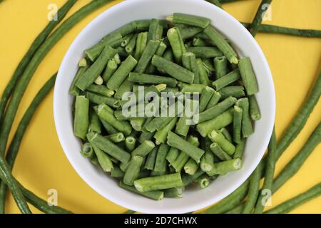 Pezzi di fagioli lunghi o pungenti in ciotola bianca, ingrediente di cottura Foto Stock